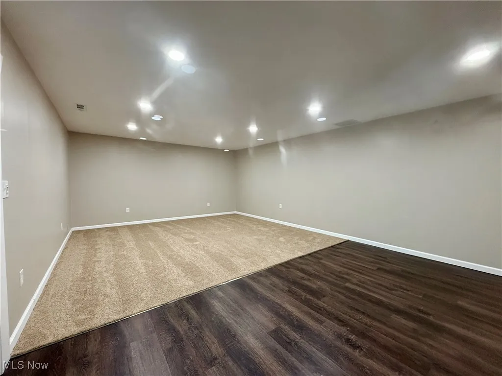 Finished below grade area with dark wood-type flooring and recessed lighting