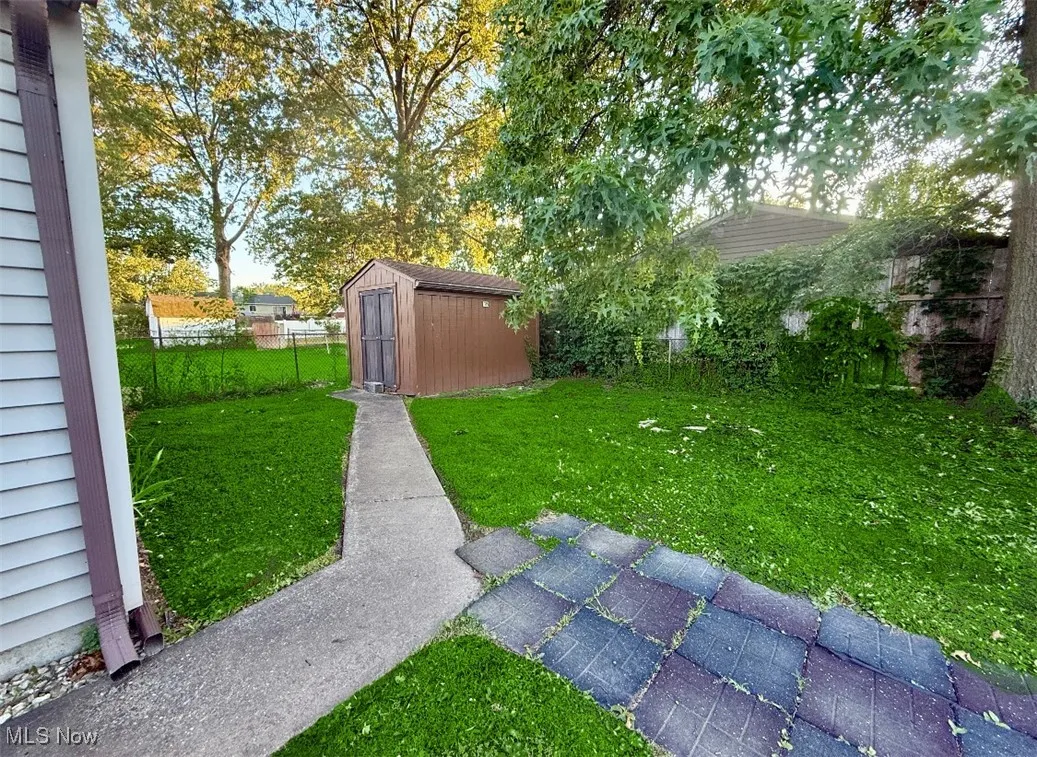 Fenced backyard featuring a shed