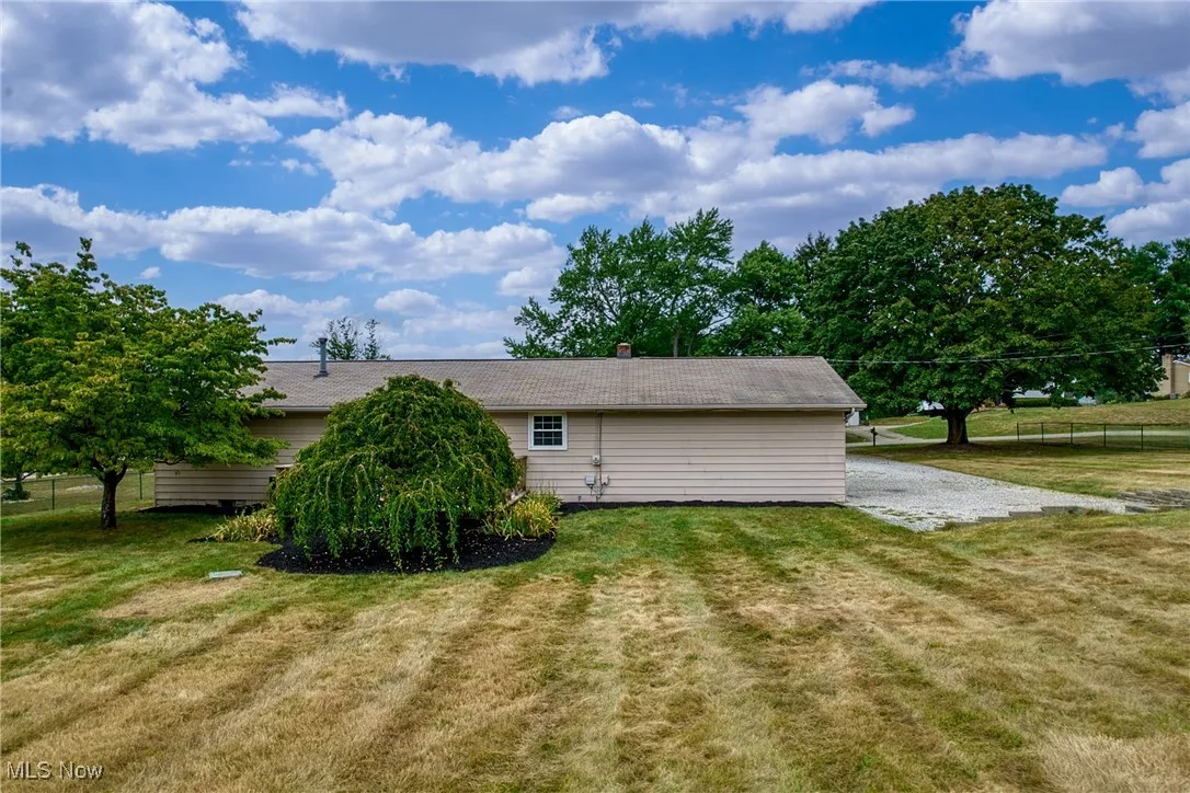Back of property with a lawn