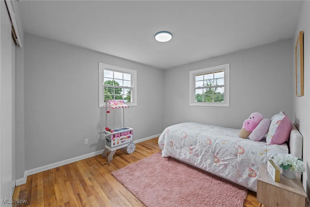 Bedroom featuring multiple windows and light wood-type flooring