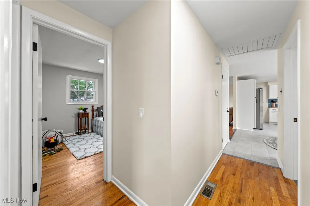 Corridor with light wood-style floors and baseboards