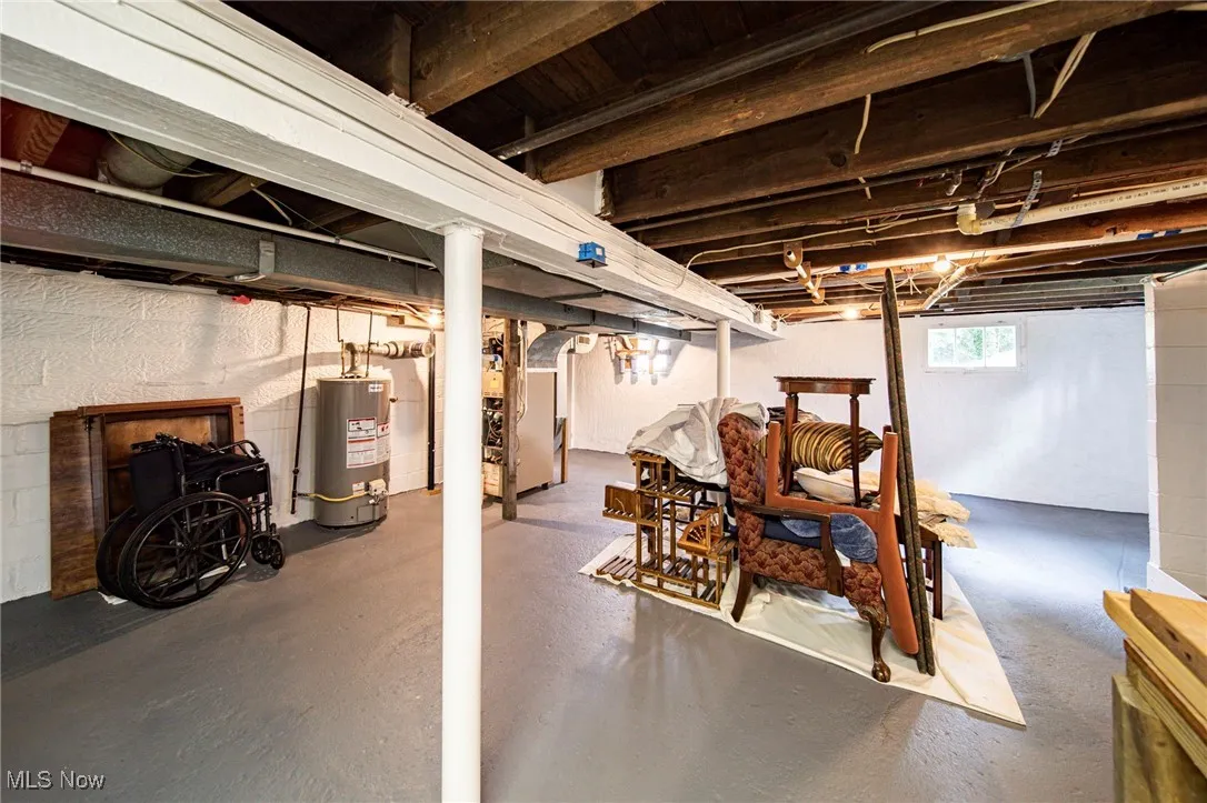 Below grade area featuring water heater and heating unit