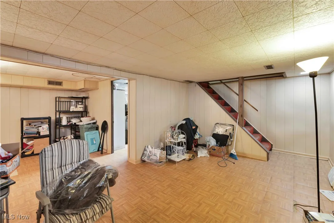 Finished basement featuring wooden walls and stairway