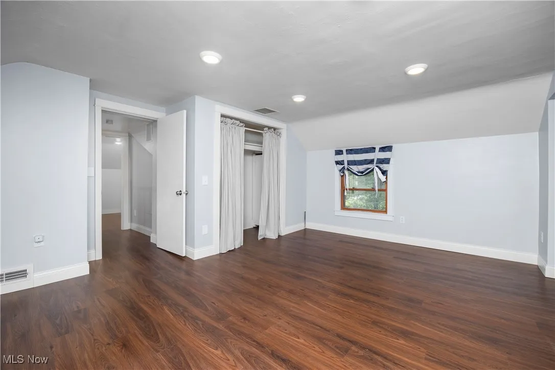 Bonus room with dark wood finished floors, vaulted ceiling, and recessed lighting