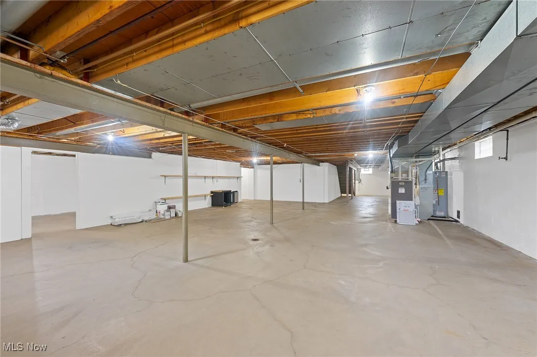 Basement featuring heating unit and water heater