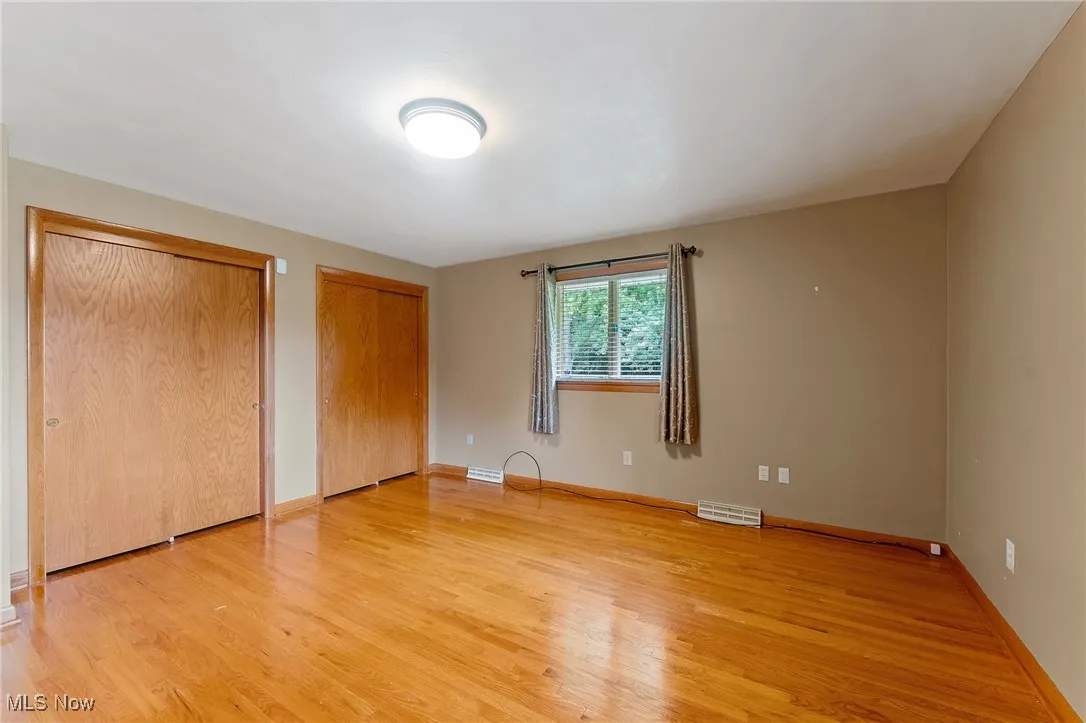 Second bedroom featuring multiple closets and light wood-style flooring