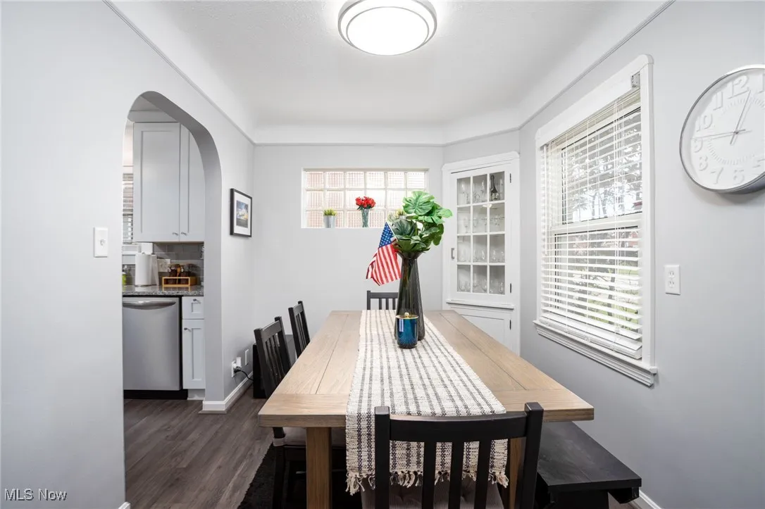 Dining room featuring arched walkways and dark hardwood floors