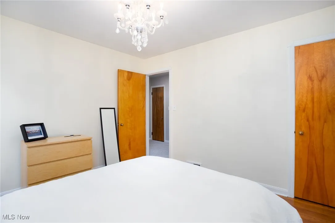 Bedroom featuring a chandelier and wood finished floors