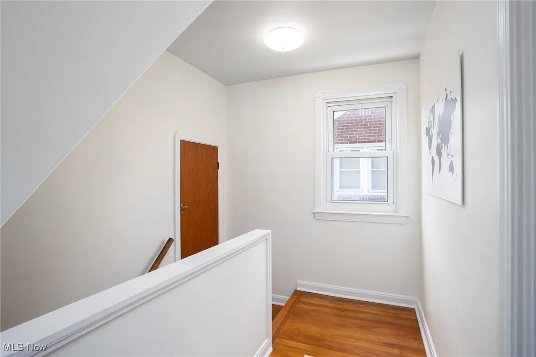 Hallway with an upstairs landing and wood finished floors