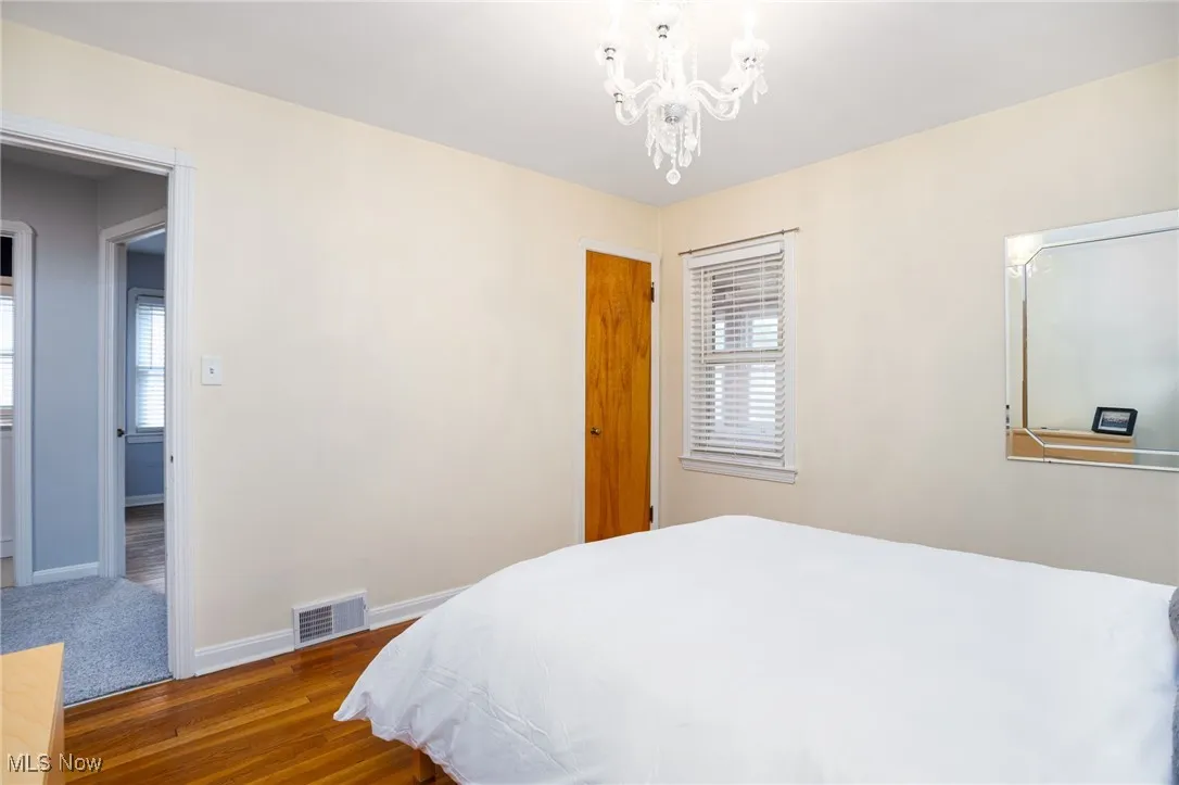 Bedroom with dark hardwood floors and a chandelier