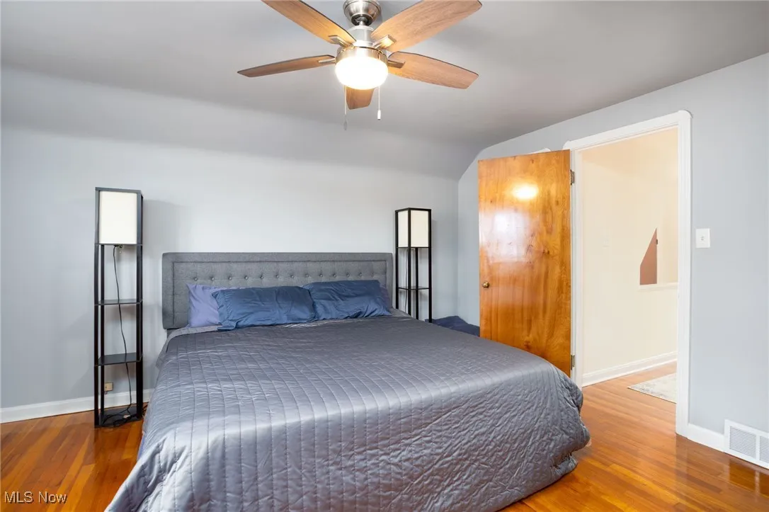 Bedroom with wood finished floors, a ceiling fan, and lofted ceiling