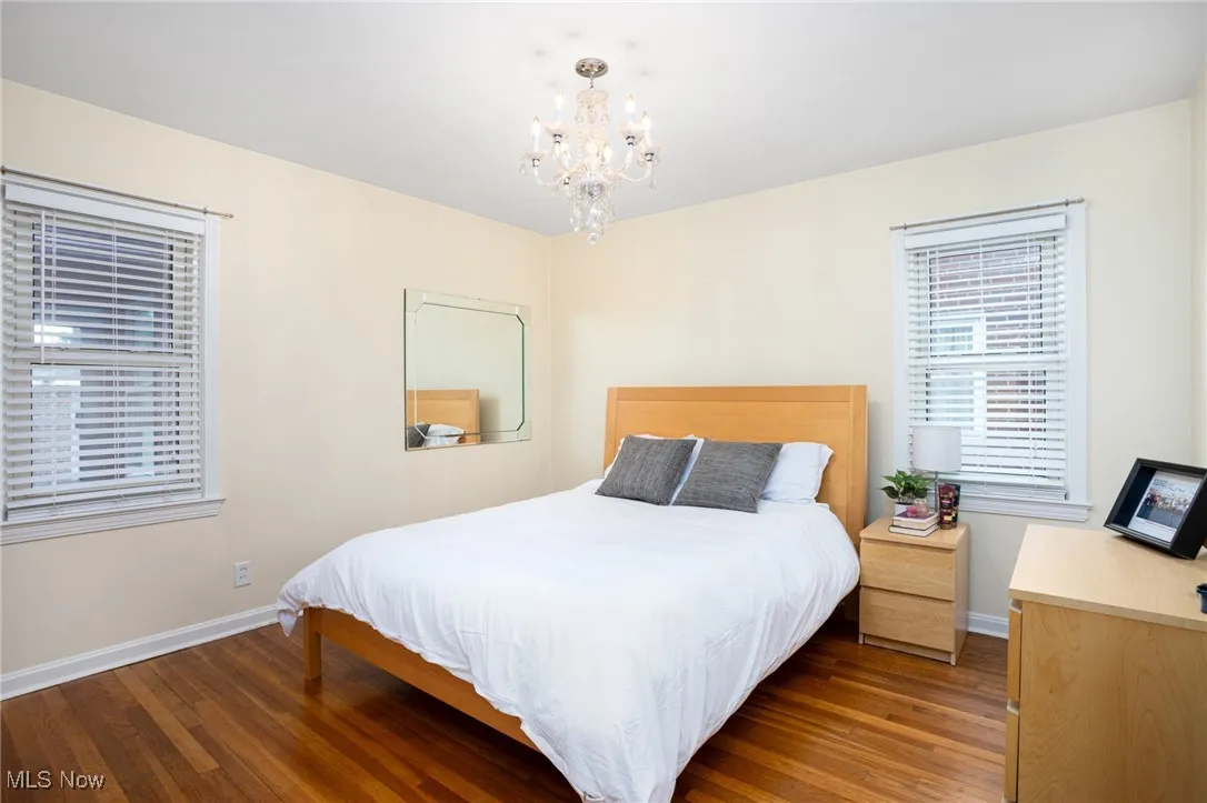 Bedroom with dark wood-type flooring and a chandelier