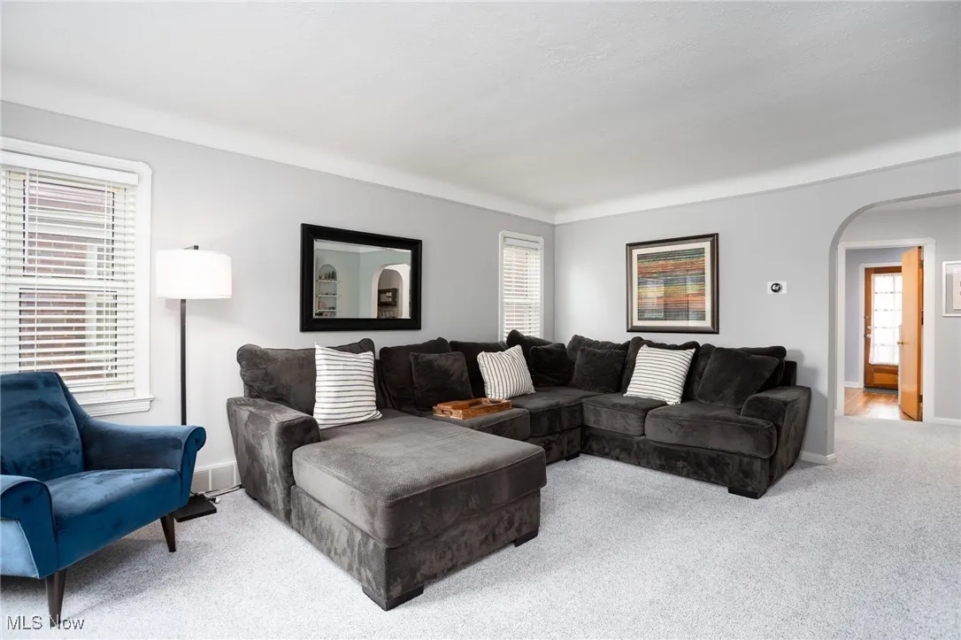 Living area featuring arched walkways and carpet