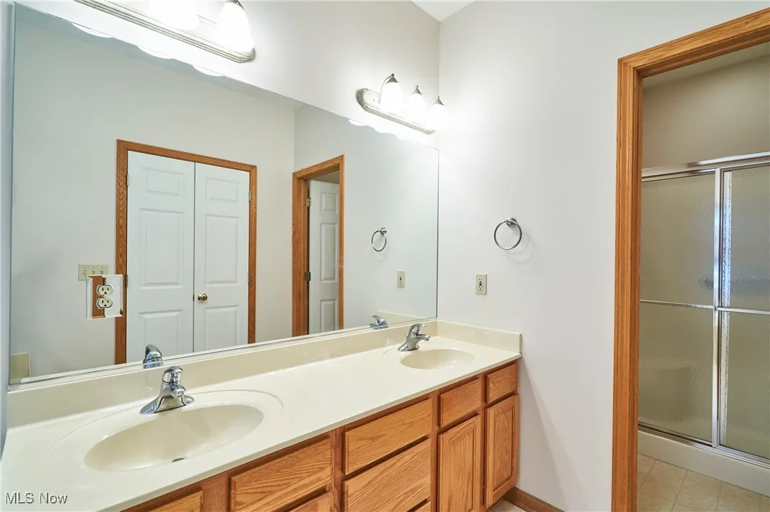 Full bath with a stall shower,  and double vanity