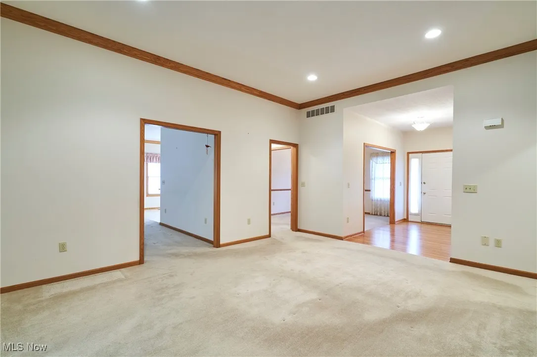 Living room with crown molding- view to foyer