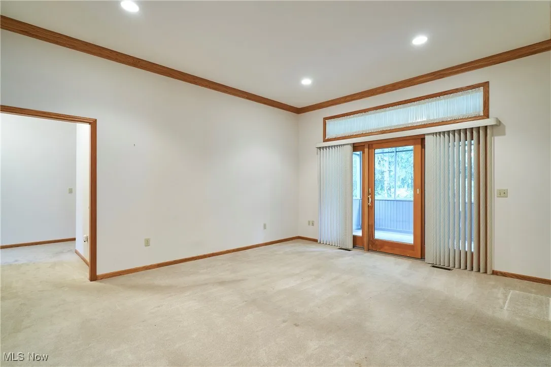 Living room with crown molding, canned lighting and glass door to screened porch