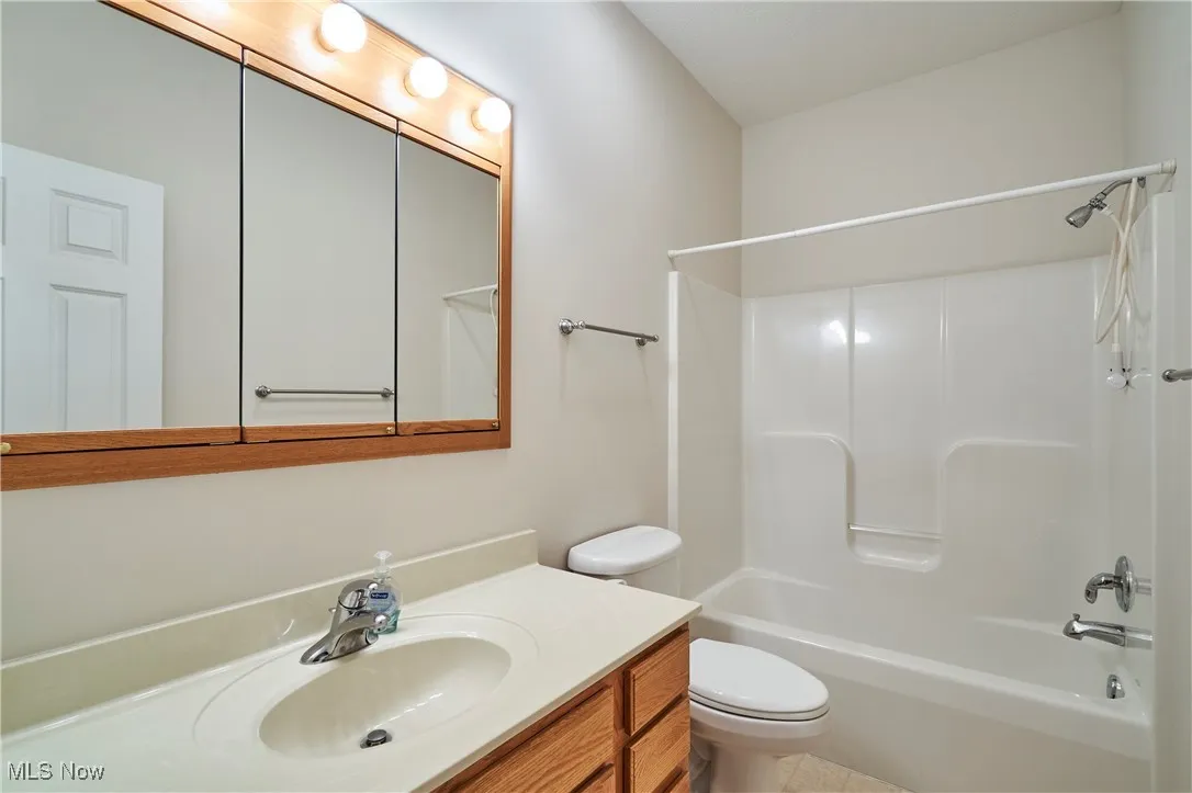 Full bath featuring shower / bath combination, oak vanity, and medicine cabinet