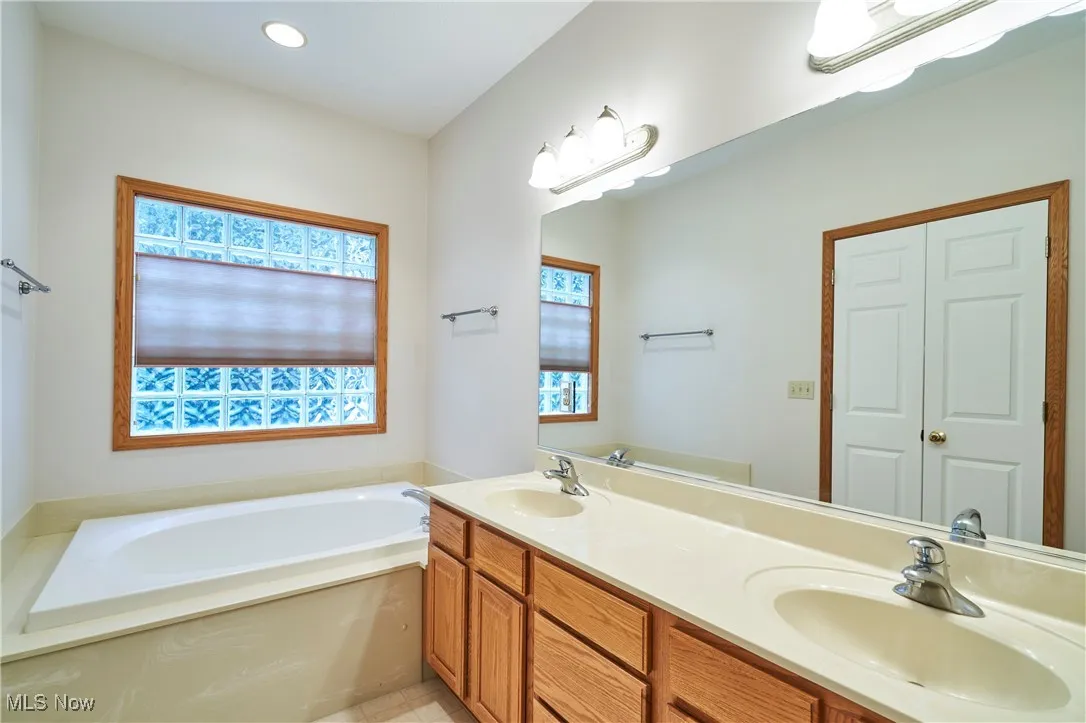 Master Bathroom featuring a garden tub, double vanity, shower and recessed lighting