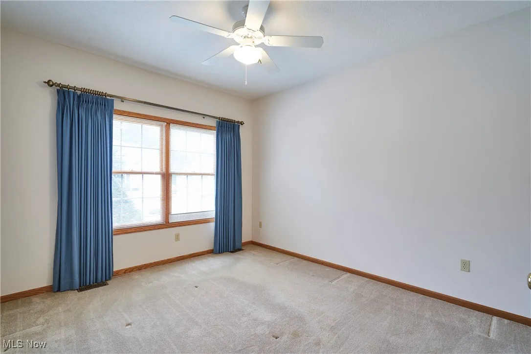 Bedroom 2 with carpet, neutral decor and ceiling fan