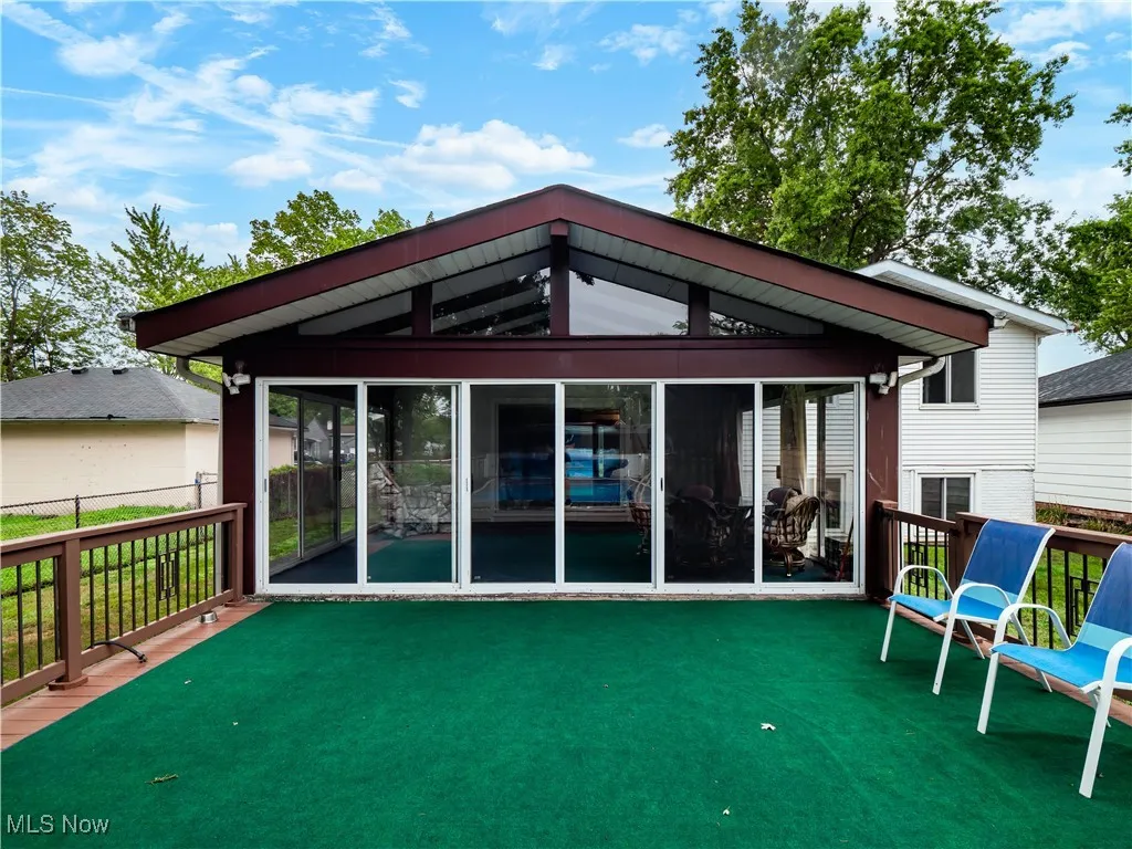 Back of house featuring a deck and a sunroom
