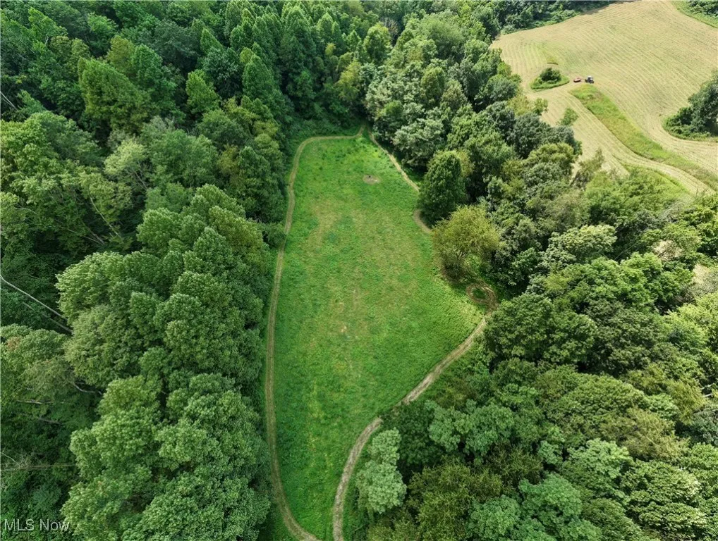 Aerial view of property and surrounding area with a forest and rural landscape
