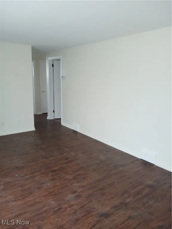 Empty room featuring dark wood-style flooring