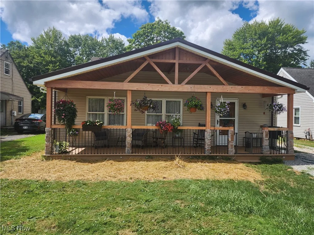 View of front of home with a front lawn and a wooden deck