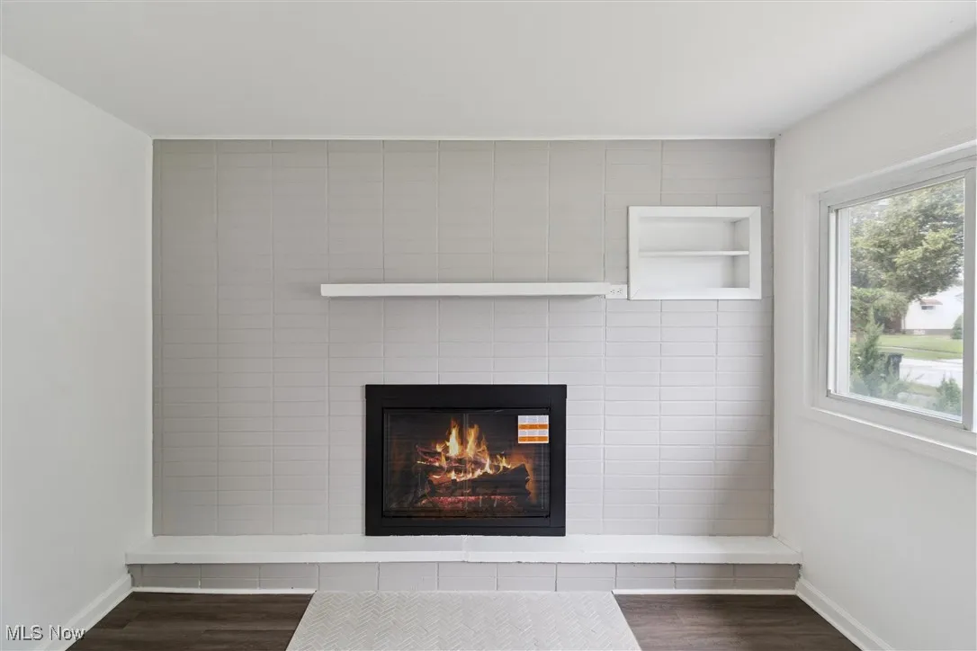 Detailed view of wood finished floors and a glass covered fireplace