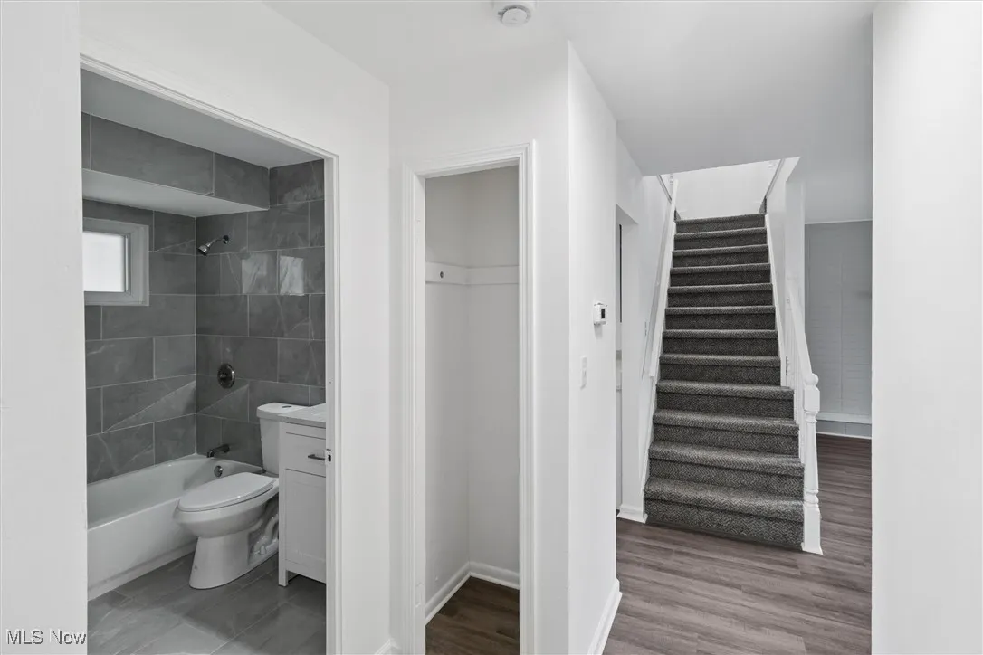Full bath with vanity, bathing tub / shower combination, and light wood-style flooring