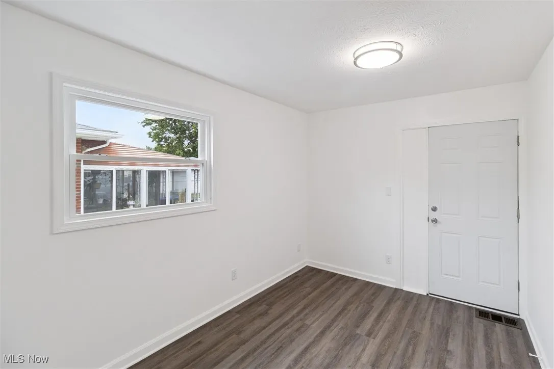 Empty room featuring dark wood finished floors and a textured ceiling