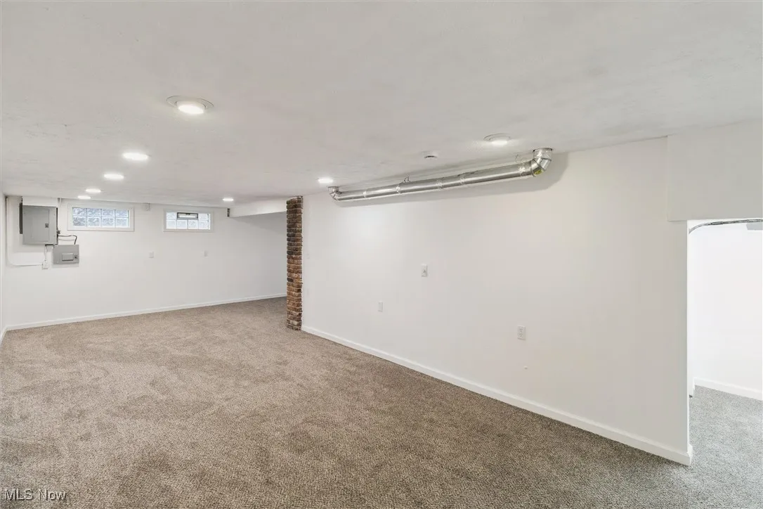 Basement with light colored carpet and electric panel
