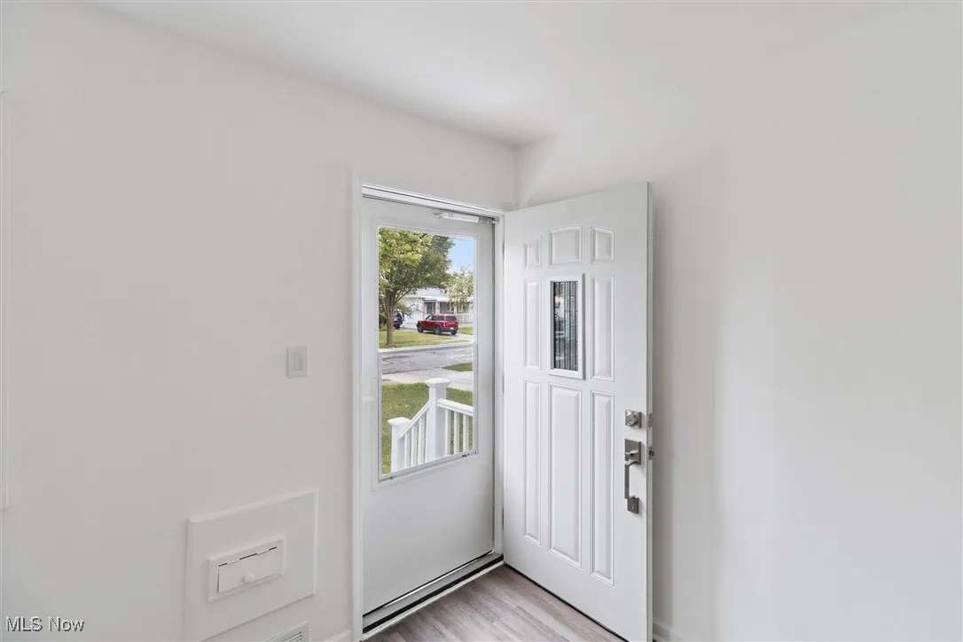 Doorway to outside with wood finished floors and baseboards