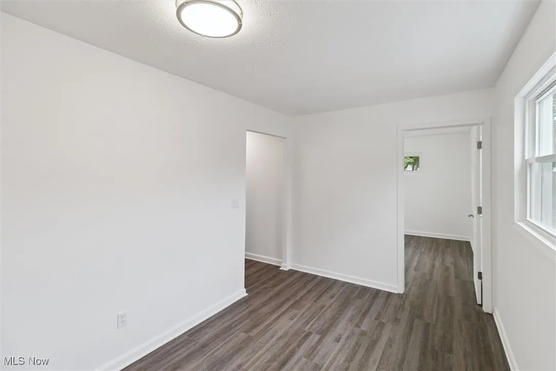 Empty room with dark wood-style flooring and a textured ceiling