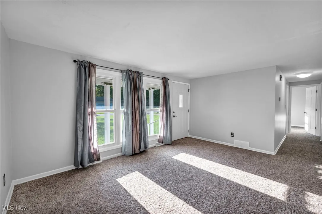 Carpeted empty room with baseboards