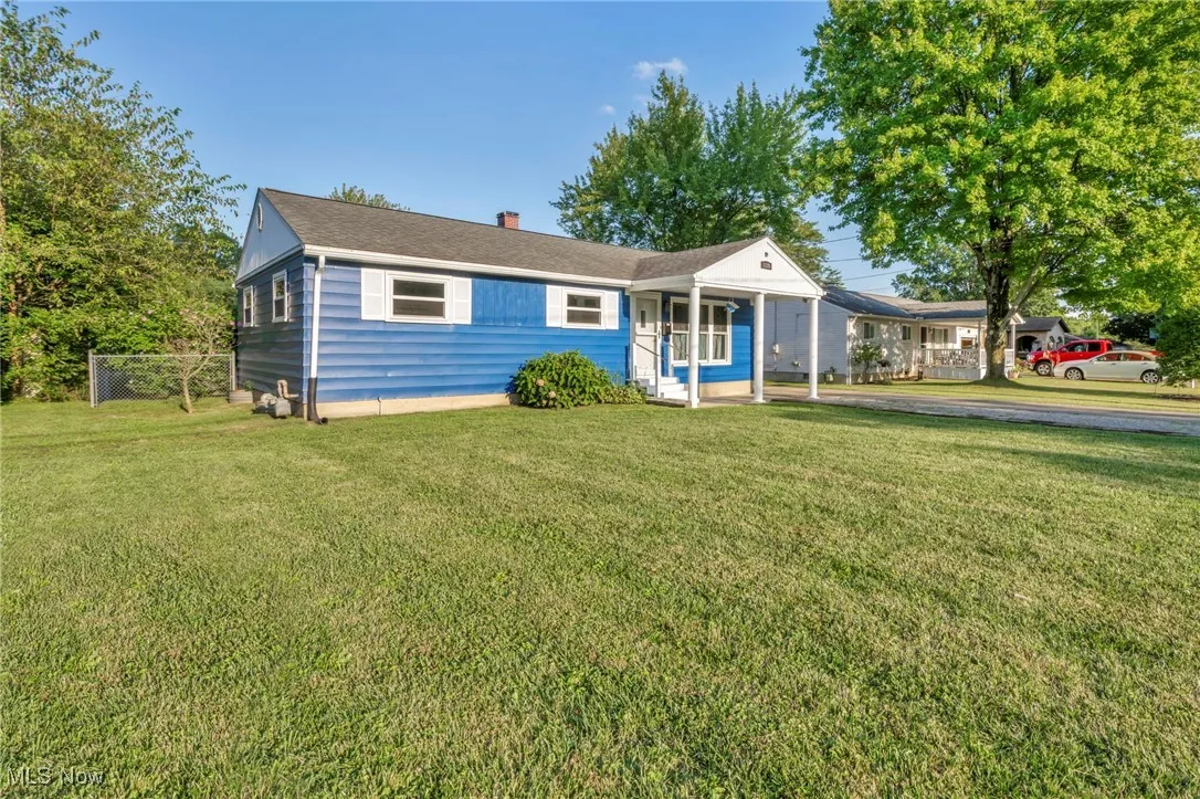 Single story home with a chimney and a front lawn