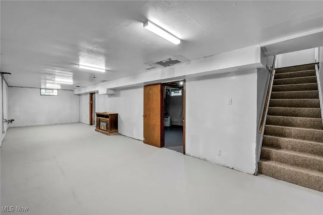 Below grade area with stairway and a textured ceiling