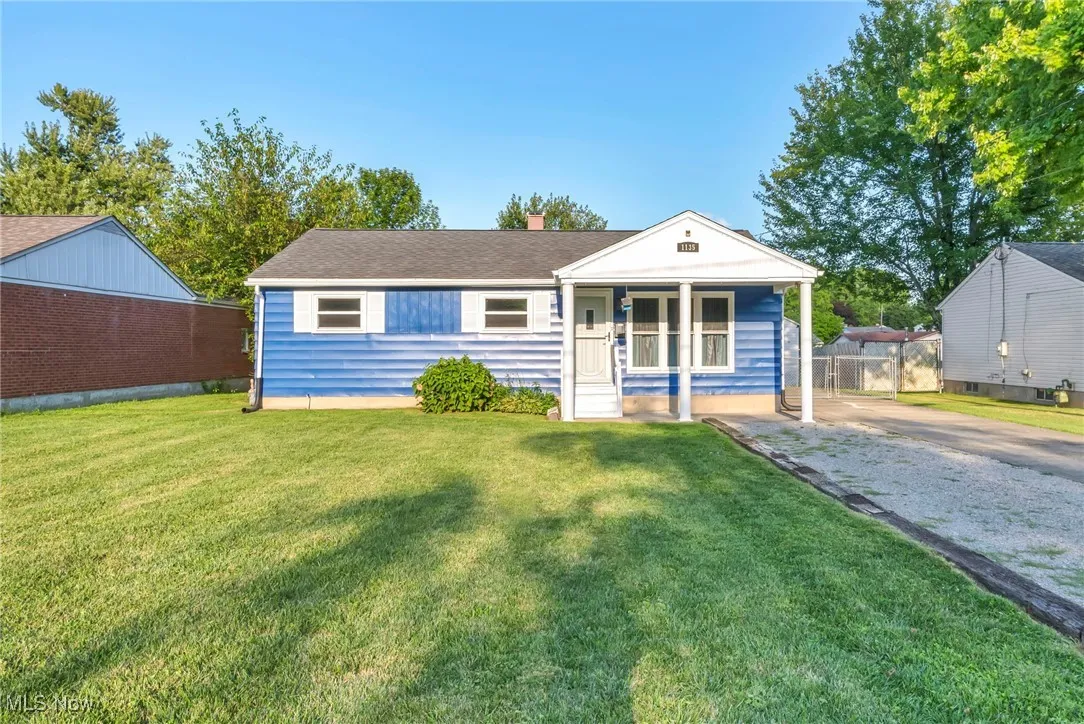 View of front of home with a front lawn, a chimney, and a porch