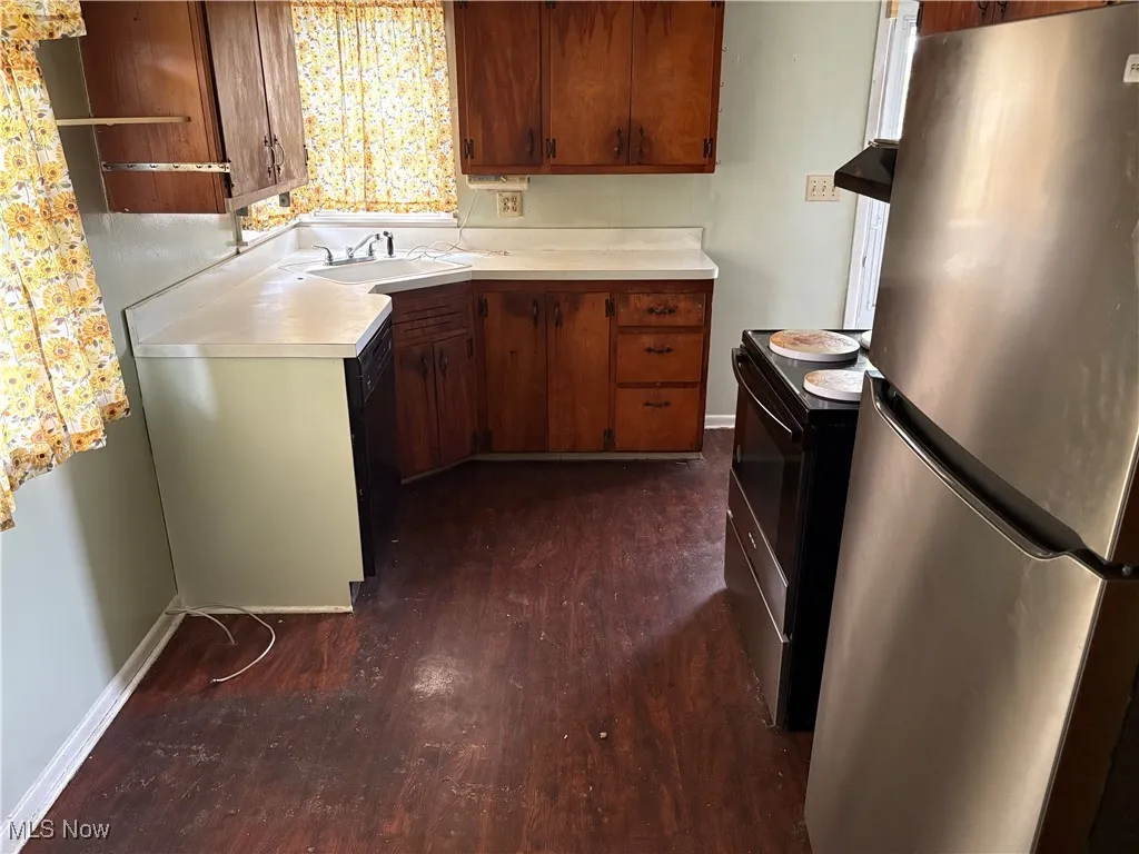 Kitchen featuring black appliances, light countertops, dark wood-type flooring, and open shelves