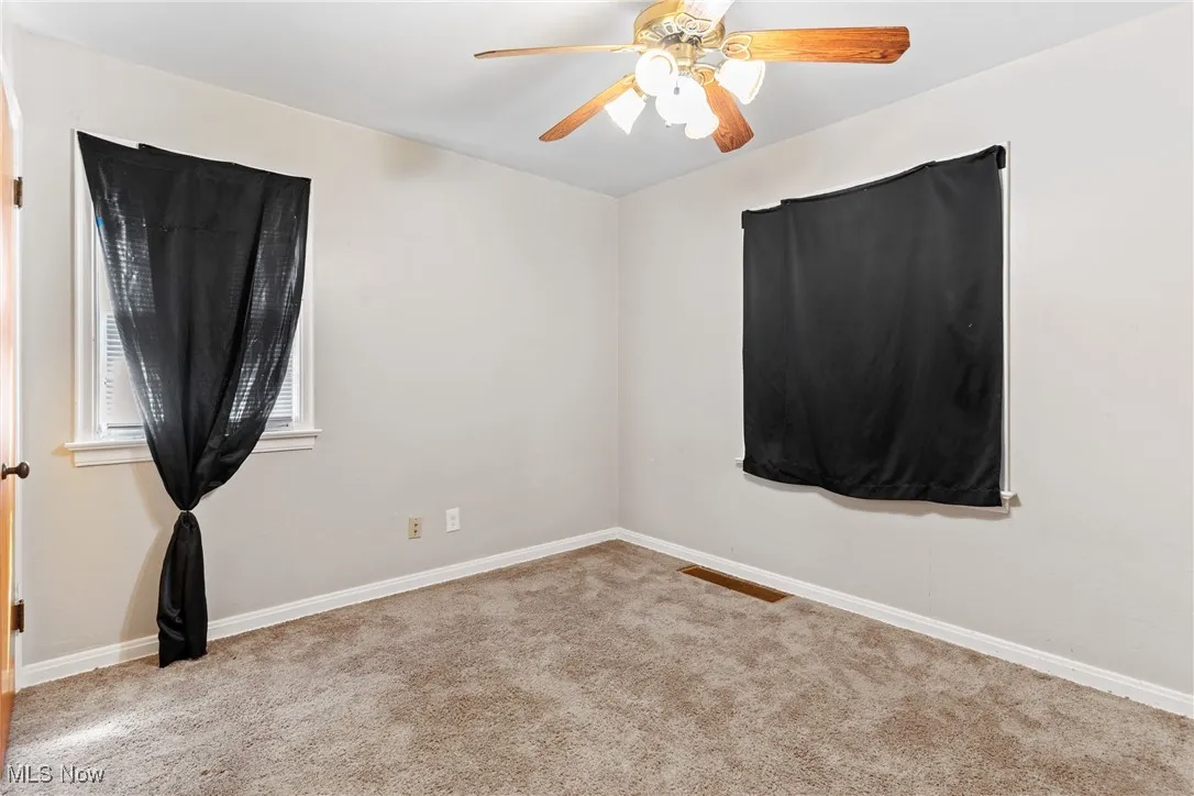Spare room with carpet and a ceiling fan