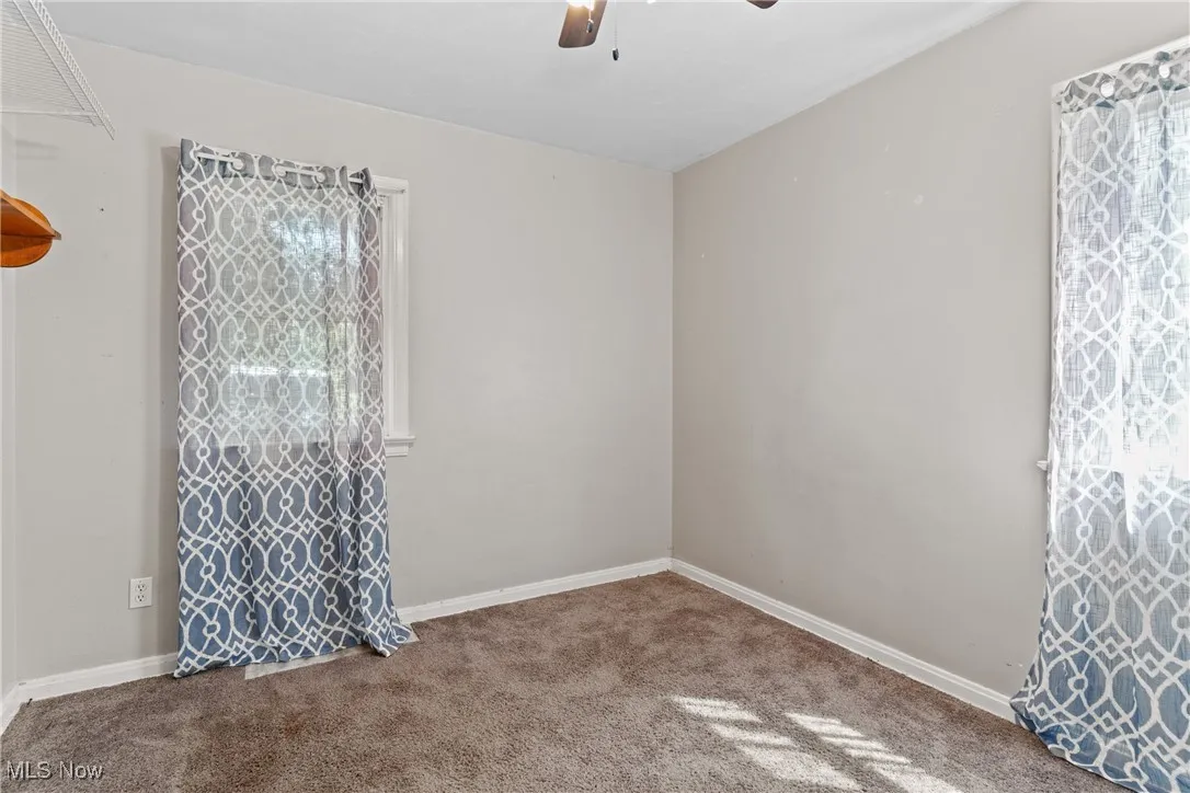 Unfurnished room with carpet flooring and a ceiling fan