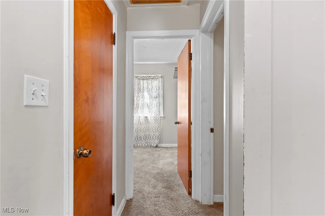 Hall with carpet flooring and baseboards