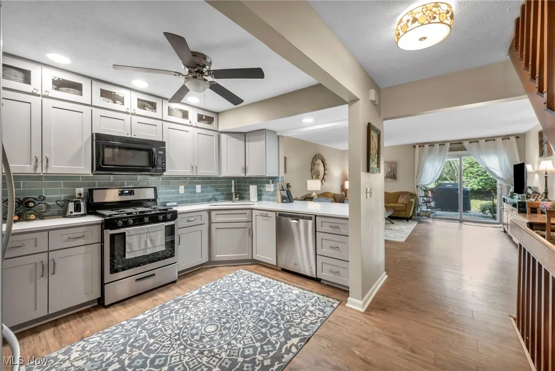 Updated Kitchen with stainless steel appliances, open floor plan, tasteful backsplash, gray cabinetry, and recessed lighting