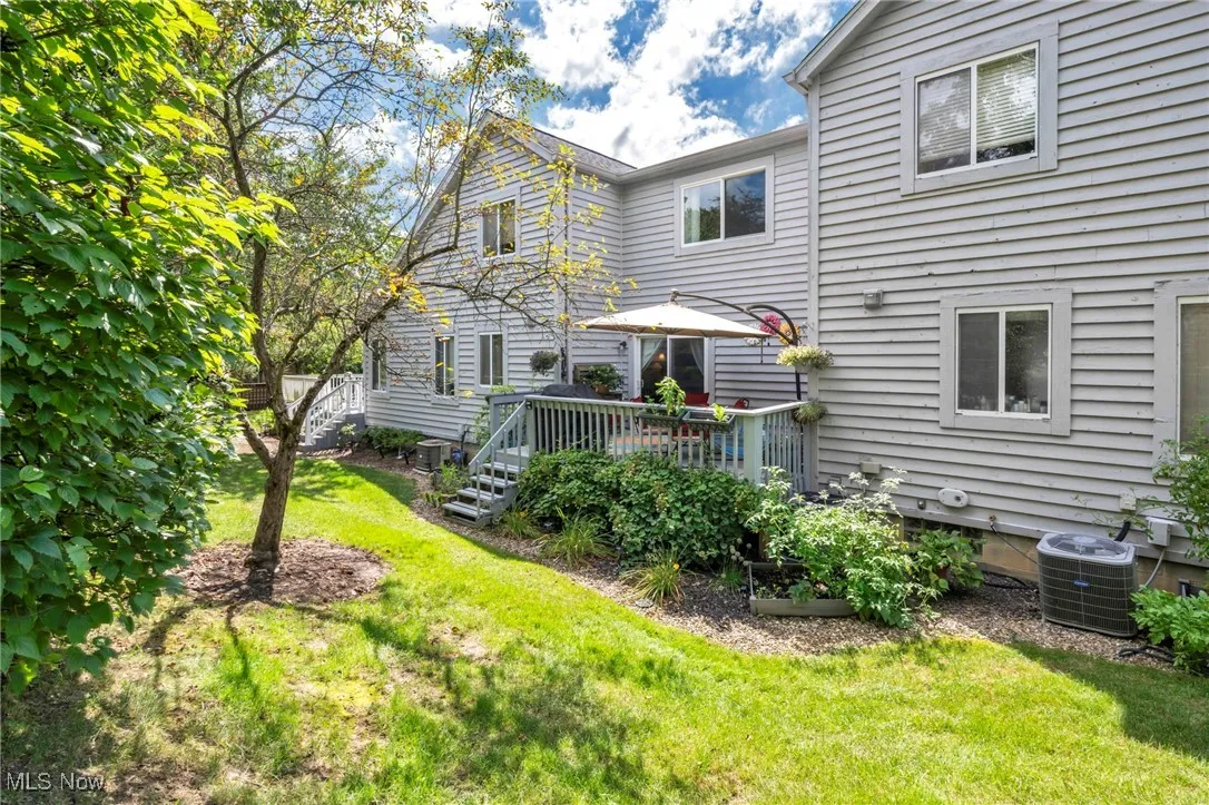 Back of property with a yard and a deck