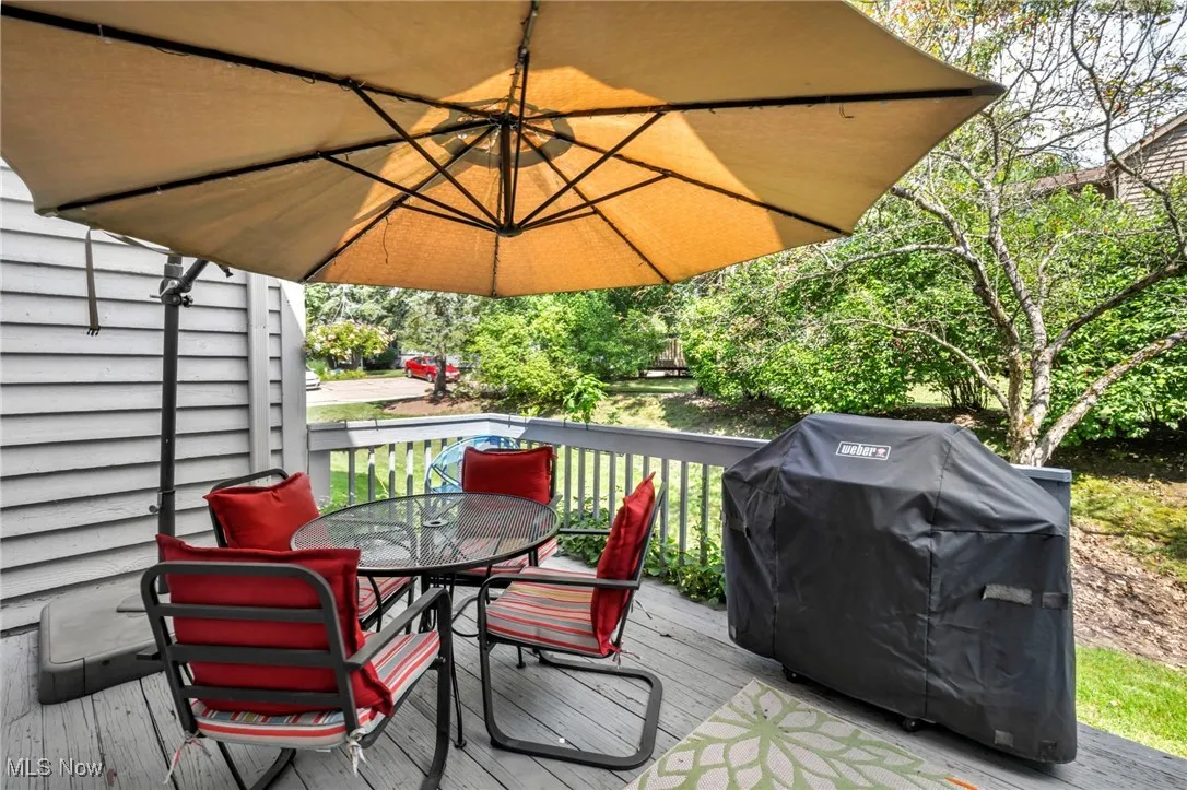 Wooden deck featuring outdoor dining space and grilling area