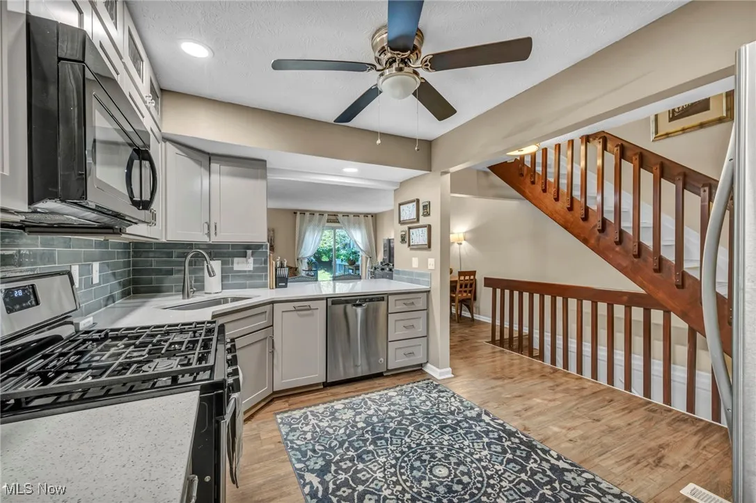 updated Kitchen featuring stainless steel appliances, recessed lighting, updated flooring, tasteful backsplash.