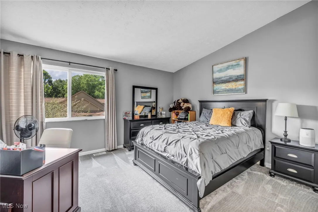 2nd Bedroom featuring light colored carpet, vaulted ceiling