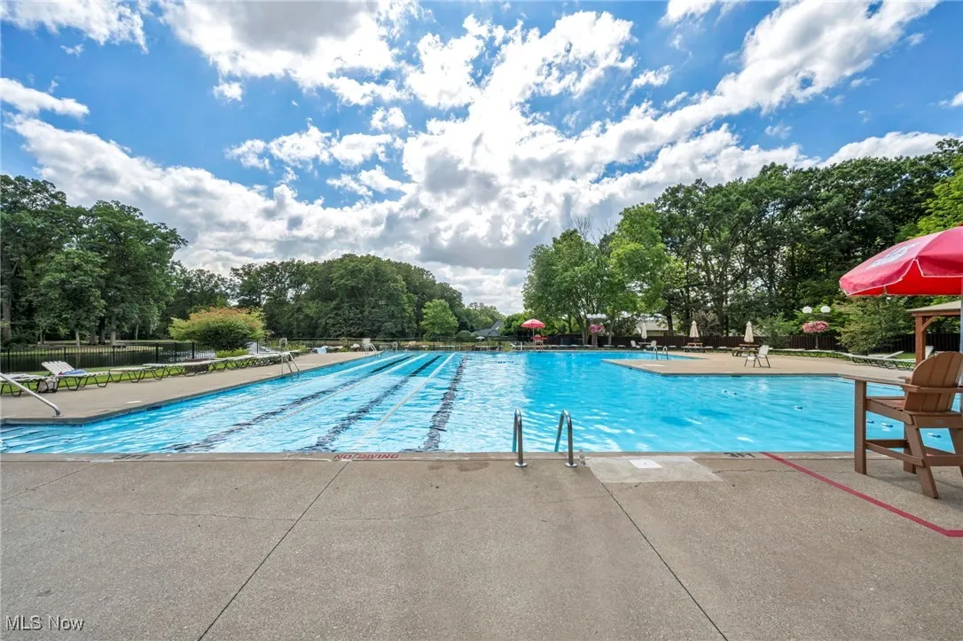Community pool with a patio and lifeguard
