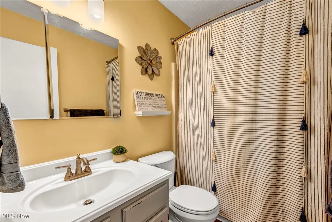 Full bathroom upstairs featuring vanity, toilet and shower