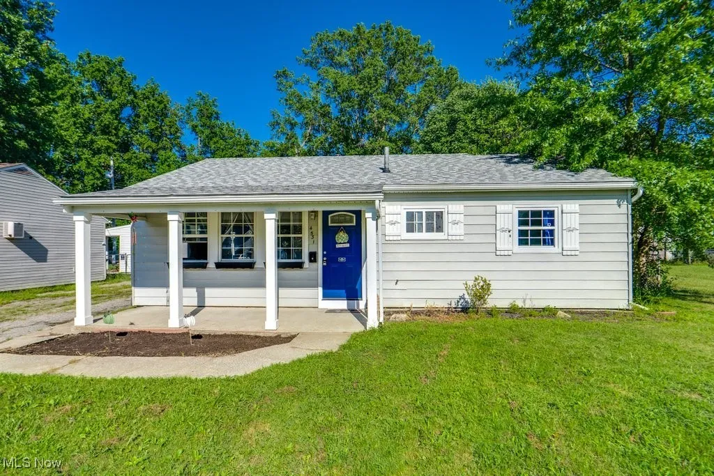 View of front facade featuring covered porch, a front yard, and a shingled roof