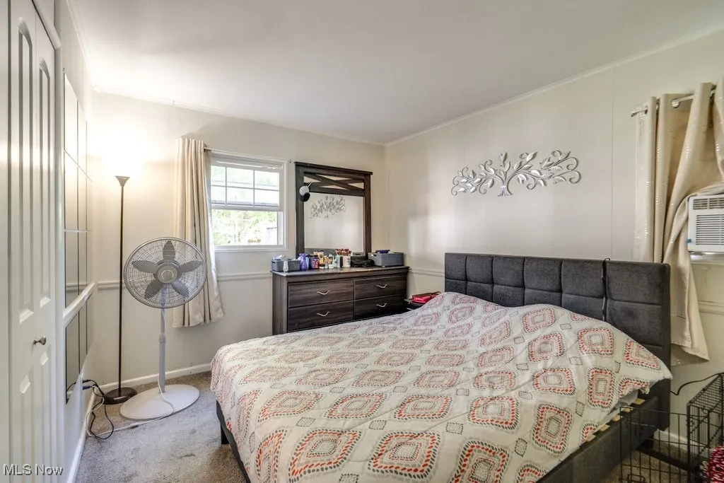 Carpeted bedroom with ornamental molding and baseboards